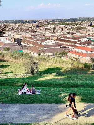 a group of people sitting on a grassy hill at Maison Ammiragli Vatican Rooms in Rome
