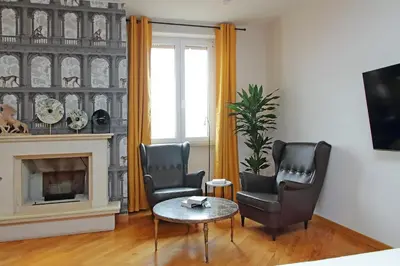a living room with two chairs and a table and a fireplace at suity I monkeys apartment in Rome