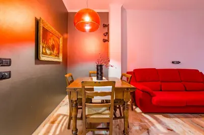 a living room with a table and a red couch at Alle Mura Aurelie Apartment in Rome