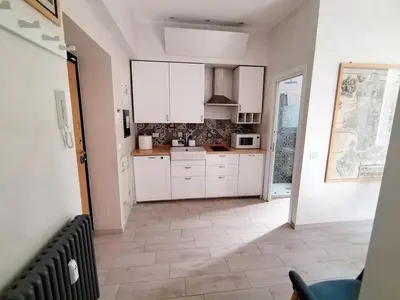 a kitchen with white cabinets and a tile floor at Il Cortile - Appartamento nel cuore di Testaccio in Rome