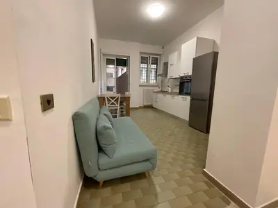 a living room with a blue couch and a kitchen at Casa Sofia Trastevere in Rome