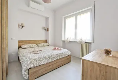a white bedroom with a bed and a window at Martina Garden in Rome