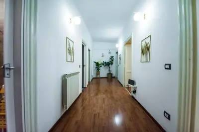 a hallway with white walls and a hard wood floor at Tibullo House in Rome