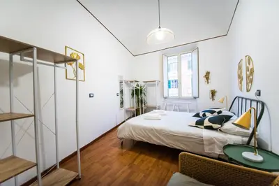 a bedroom with a bed and a table with a lamp at Tibullo House in Rome