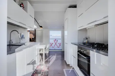 a kitchen with white cabinets and a counter top at Casa Doni Roma in Rome