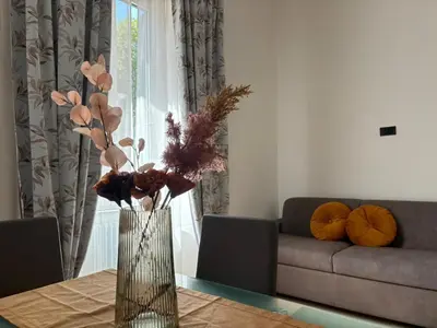a vase with flowers on a table in a living room at House of Wonders in Rome