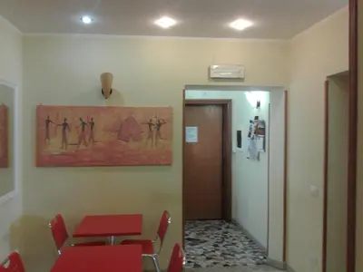 a waiting room with a table and chairs and a painting on the wall at Alenic in Rome