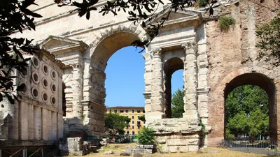 an ancient building with three arches in front of it at Alenic in Rome