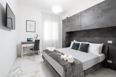 a bedroom with a large bed and a desk at Picorini House in Rome