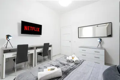 a white bedroom with a desk and chairs at Picorini House in Rome