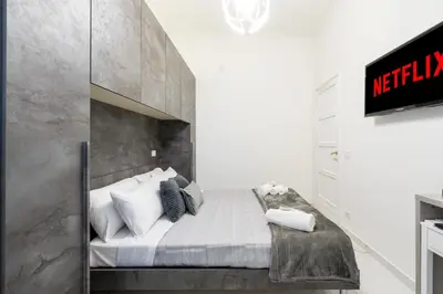 a bedroom with a large bed with a concrete wall at Picorini House in Rome