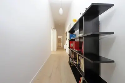 a long hallway with black bookshelves in a house at FM Apartment in Rome