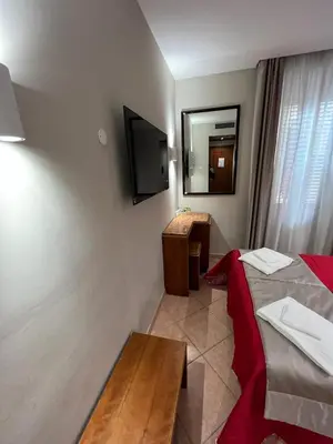 a hotel room with a bed and a desk and a television at Affittacamere REGIO in Rome