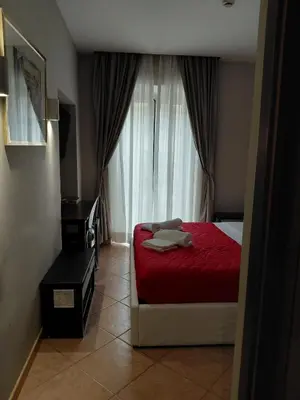 a bedroom with a red bed with two towels on it at Affittacamere REGIO in Rome