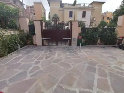 a stone patio with a gate and some buildings at Alessandro Luxury Home Rome in Rome