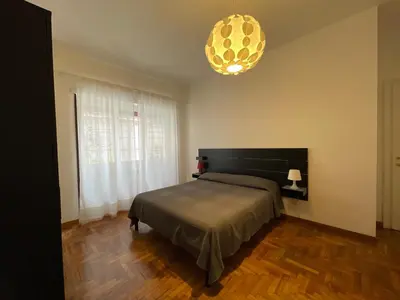 a bedroom with a bed and a large window at MySweetHome near the Vatican in Rome