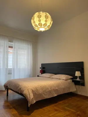 a bedroom with a large bed and a chandelier at MySweetHome near the Vatican in Rome