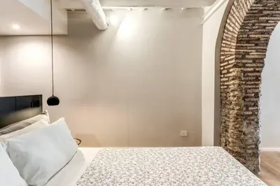 a bedroom with a bed and a brick wall at Suite Orsoline Spanish steps in Rome