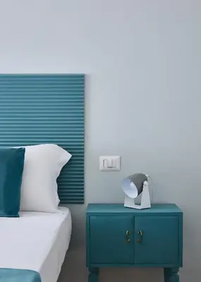 a bedroom with a blue nightstand next to a bed at Domus Modista (Musei Vaticani) in Rome