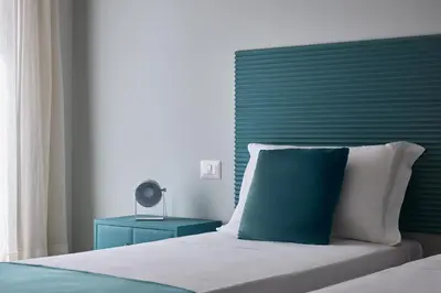 a bed with a green headboard and a blue night stand at Domus Modista (Musei Vaticani) in Rome
