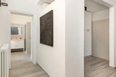 a hallway with white walls and a painting on a wall at Retro Flat Termini in Rome