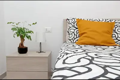 a bedroom with a bed with a yellow pillow and a plant at La Casa di Carmine in Rome
