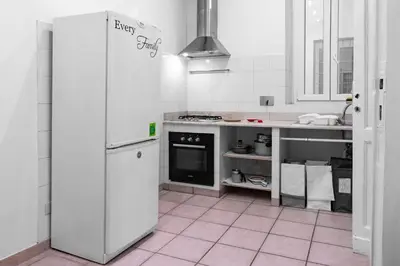 a white kitchen with a refrigerator and a stove at vatican apartment gianicolo in Rome