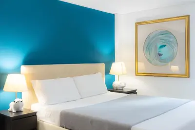 a bedroom with a bed with two lamps and a blue wall at Lovely Cozy Apartment Parioli in Rome