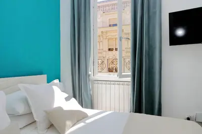 a bedroom with a white bed and a window at Fontana di Trevi dream home in Rome