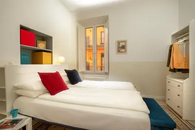 a bedroom with two white beds with red pillows at St.Peter's1928 in Rome