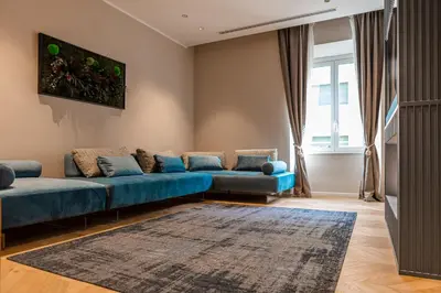 a living room with a blue couch and a rug at La Dolce Vita Luxury Apartment in Rome