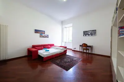 a living room with a red couch and a table at Casa Aosta in Rome