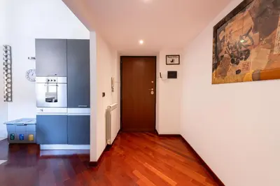 a kitchen with blue cabinets and a brown door at Casa Aosta in Rome