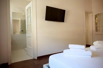 a bathroom with a television on a wall with towels on a bed at Riboty 21 in Rome