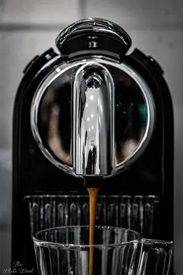 a coffee maker is pouring coffee into a cup at The Little Big House in Rome