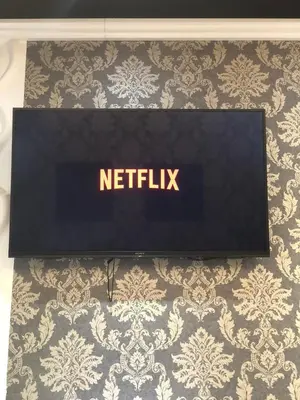 a sign that says netflix sitting on a bed at Black & White G&G in Rome