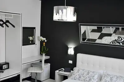 a bedroom with a white bed and a black wall at Black & White G&G in Rome