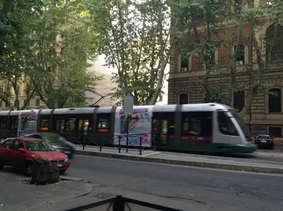 a bus driving down a city street with a red car at Black & White G&G in Rome