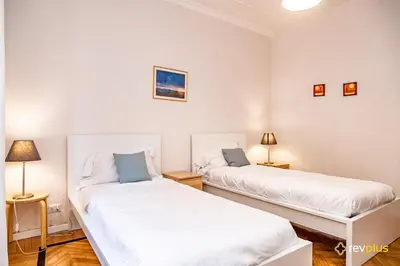 two beds in a room with white walls at Mecenate Apartment Fori Imperiali in Rome