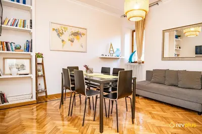 a dining room with a table and chairs and a couch at Mecenate Apartment Fori Imperiali in Rome