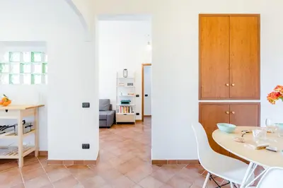 a kitchen and dining room with white walls and a table and chairs at Vinylogy Apartment 5to Piano in Rome