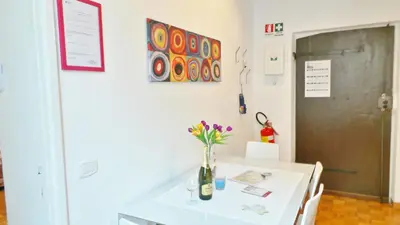 a white table with a vase of flowers on it at Casa Tua a Monti in Rome