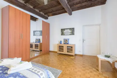 a room with a bed and a table and a door at Casa Tua a Monti in Rome