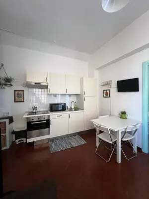 a kitchen with white cabinets and a table in it at Apartment - Laterano 85 in Rome