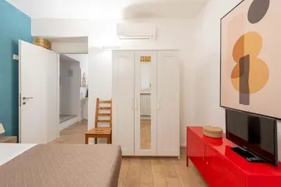 a living room with a red dresser and a tv at SuityRHome San Pietro 99 in Rome