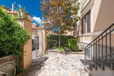 a walkway between two buildings with a tree at SuityRHome San Pietro 99 in Rome