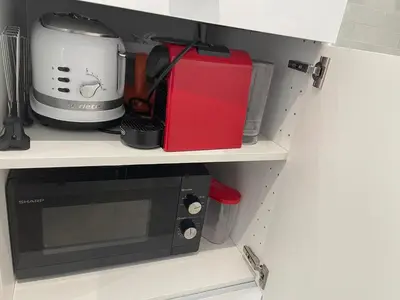 a black microwave oven sitting on top of a shelf at Little Aventino BnB in Rome
