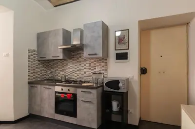 a kitchen with a stove top oven next to a door at GuestHost - San Lorenzo Welcoming Apartment in Rome