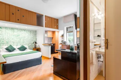a bedroom with a large bed and a kitchen at Studio Suite Aurelia Antica in Rome