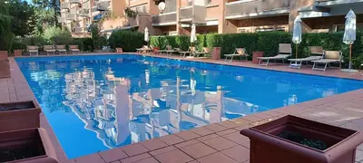a swimming pool with a reflection of a building at Studio Suite Aurelia Antica in Rome